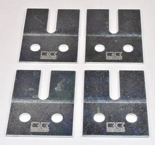 Vier metallene Flachstahlplatten mit zwei Löchern und einer Aussparung, markiert mit dem Logo von Remko, auf heller Unterlage angeordnet.