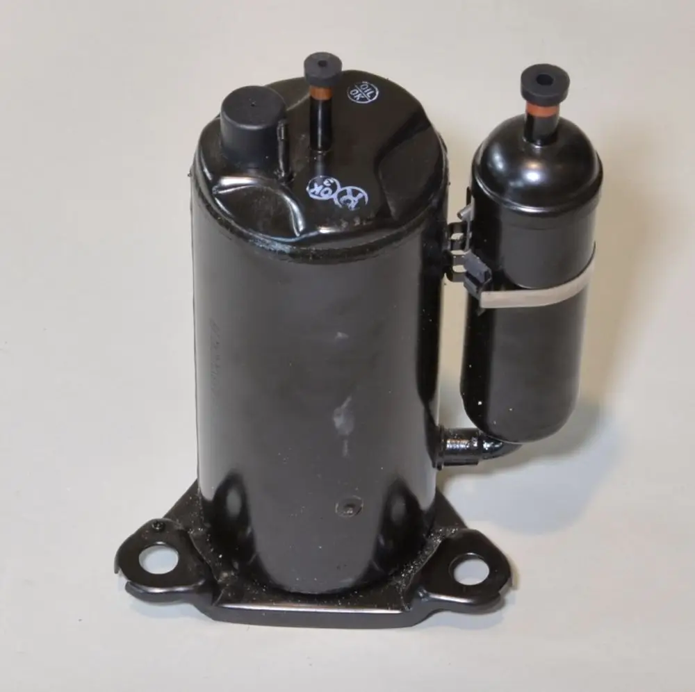 Schwarzer Kompressor von Remko mit zwei Anschlüssen, montiert auf einer Basisplatte. Das Design inkludiert einen separaten, kleineren Komponentenbereich.