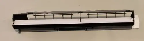 Schwarze Austrittslamellen für Lüftungssysteme, eingesetzt in Remko-Produkten, mit einer weißen Blende und mehreren Halterungen zur Montage.