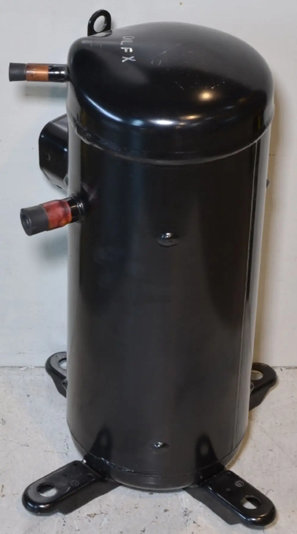 Schwarzer zylindrischer Kompressor mit zwei Anschlüssen, montiert auf vier Halterungen. Produkt scheint von Remko zu sein.