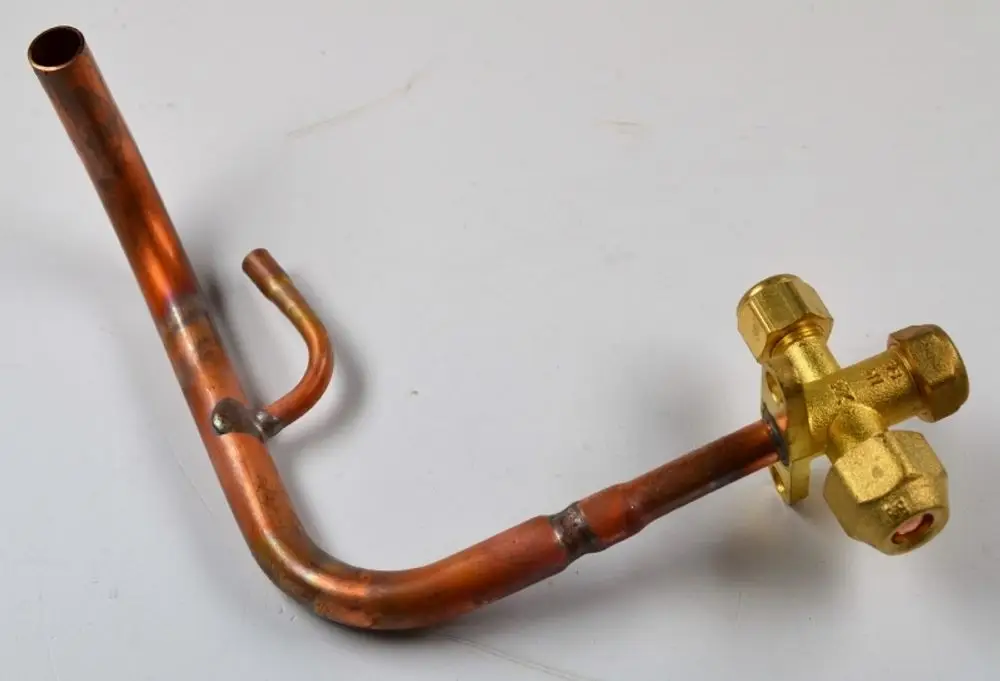 Kupferrohr mit einem angeschraubten Ventil, hergestellt von Remko. Das Ventil hat mehrere Ausgänge und ist in einem gebogenen Design ausgeführt.