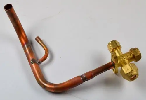 Kupferrohr mit einem angeschraubten Ventil, hergestellt von Remko. Das Ventil hat mehrere Ausgänge und ist in einem gebogenen Design ausgeführt.