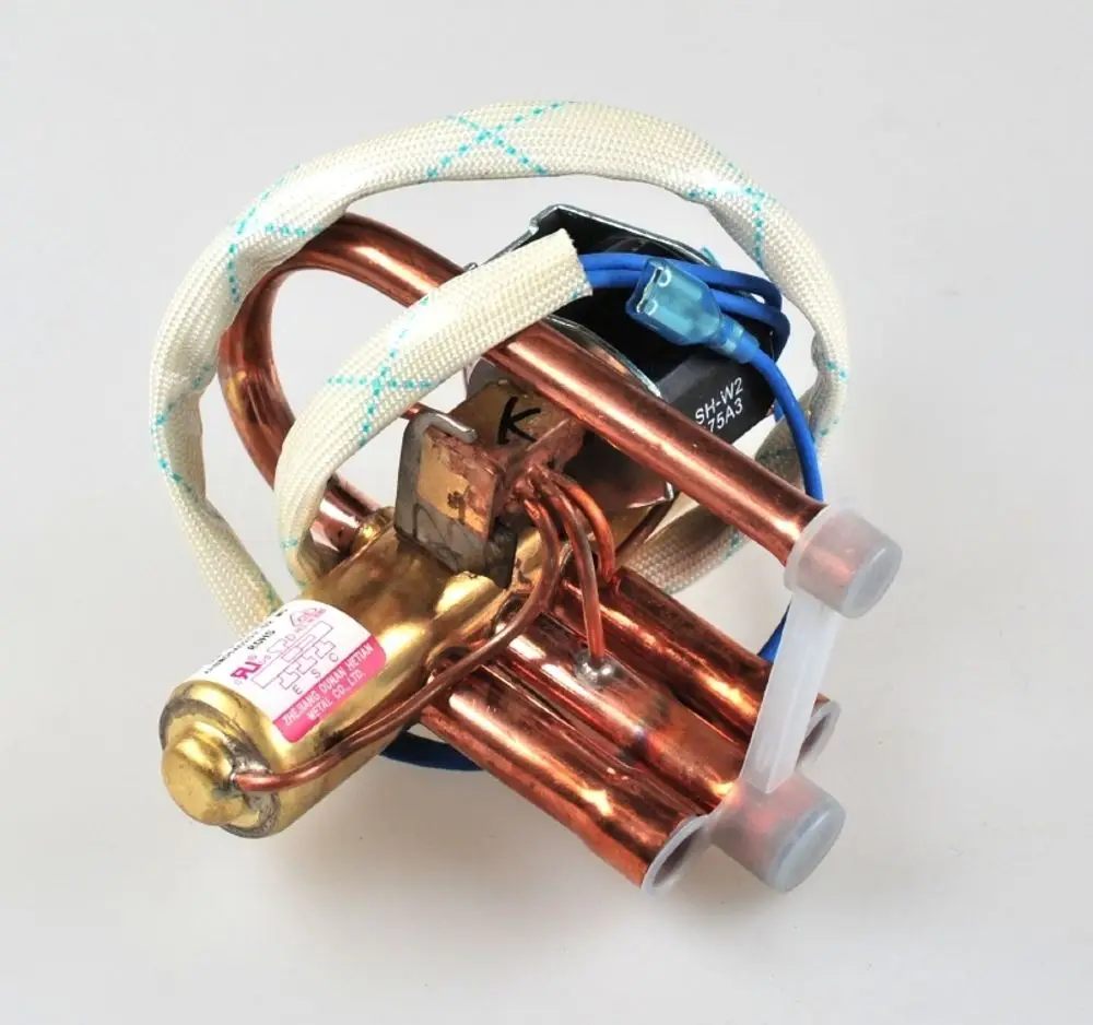 Umkehrventil von Remko mit kupfernen Rohren und elektrischen Anschlüssen. Das Produkt ist für den Einsatz in Heizungs- und Kühlsystemen konzipiert.