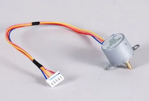 Grauer Elektromotor mit vier farbigen Kabeln. Der Motor ist mit einem Stecker verbunden und wird häufig in Anwendungen von Remko verwendet.