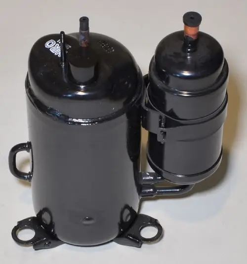 Schwarzer Kompressor mit zwei Zylindern und Anschlüssen, angebracht an der Basis, von der Marke Remko.