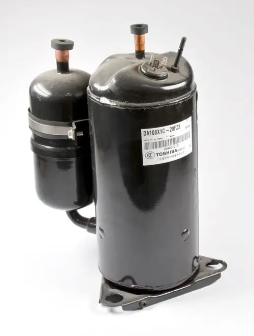 Kompressor von Remko, schwarz lackiert, mit zwei Anschlussrohren und einem seitlichen Anschluss. Sichtbare Typenbezeichnung und Montageplatte an der Unterseite.