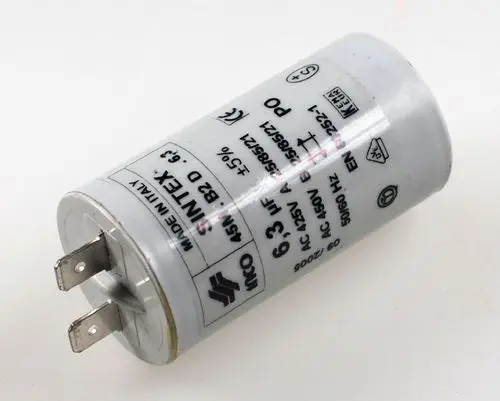 Kondensator mit weißen Gehäuse und zwei Metallanschlüssen, beschriftet mit technischen Informationen, Hersteller Remko.