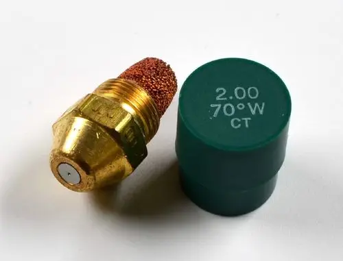 Öldüse von Remko mit goldenem Gehäuse und kupferner Filterspitze, neben einem grünen Deckel mit Aufschrift.