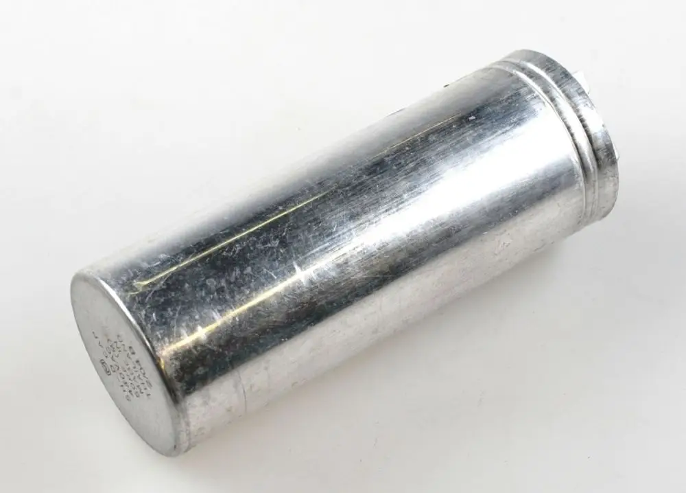Aluminiumgefertigter Zylinder mit glatter Oberfläche, möglicherweise ein Kondensator, wahrscheinlich von der Marke Remko, auf weißem Hintergrund.