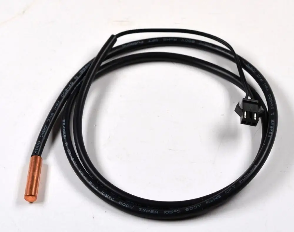 Sensor mit einem metallischen Kopf und einem erkennbaren Stecker, auf einem schwarzen Kabel. Produkt von Remko zur Temperaturmessung in Verdampfersystemen.