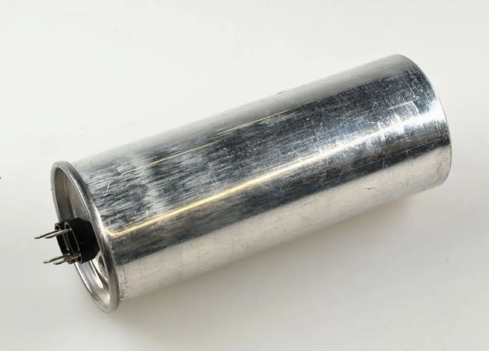 Metallischer Kondensator mit zwei Anschlüssen. Gehäuse ist glatt und zylindrisch. Produkt von Remko, geeignet für bestimmte Ventilatoranwendungen.