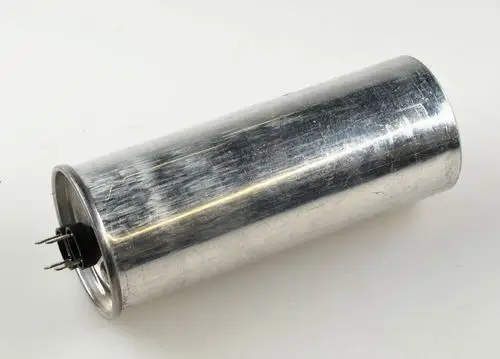 Metallischer Kondensator mit zwei Anschlüssen. Gehäuse ist glatt und zylindrisch. Produkt von Remko, geeignet für bestimmte Ventilatoranwendungen.