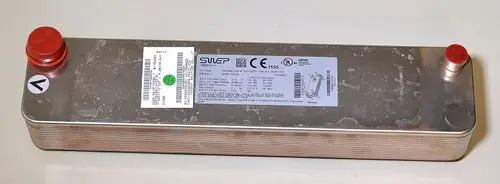 Verdampfer von Remko mit Metallgehäuse, zwei Anschlüssen an den Enden und Etikett mit technischen Daten. Oberfläche weist Gebrauchsspuren auf.