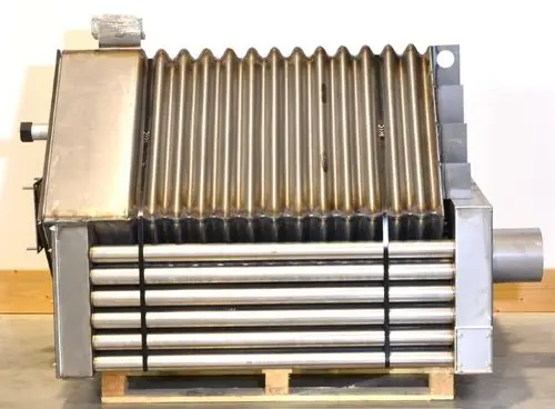 Brennkammer aus Edelstahl mit gerippter Oberfläche, charakteristischem Design und anschlussfertigen Rohren, präsentiert von Remko, auf einem Holzgestell.