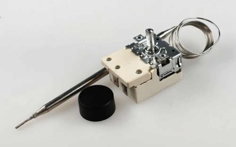 Raumthermostat von Remko mit einem verstellbaren Drehknopf, einem Sensor und einer Anschlussleitung, montiert auf einem weißen Untergrund.