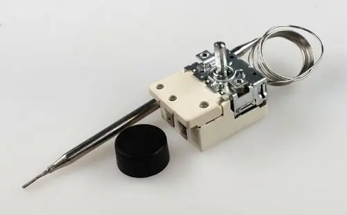 Raumthermostat von Remko mit einem verstellbaren Drehknopf, einem Sensor und einer Anschlussleitung, montiert auf einem weißen Untergrund.