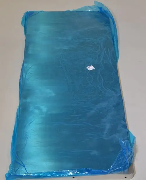 Eingepacktes Metallpaneel in grüner Folie, mit sichtbarem Preisschild. Hersteller ist Remko. Das Produkt hat eine flache und glatte Oberfläche.