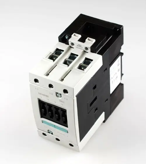 Kompressorschütz der Marke Remko in schwarzer und weißer Farbgestaltung, mit drei Anschlüssen und einer Modulbauweise, abgebildet auf neutralem Hintergrund.