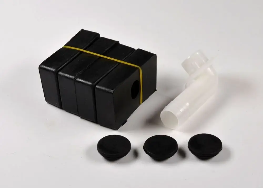 Standfüße in Schwarz, bestehend aus einem Stapel Bauteilen und drei runden Gummistoppern, ergänzt durch ein einzelnes Plastikrohr. Hersteller: Remko.