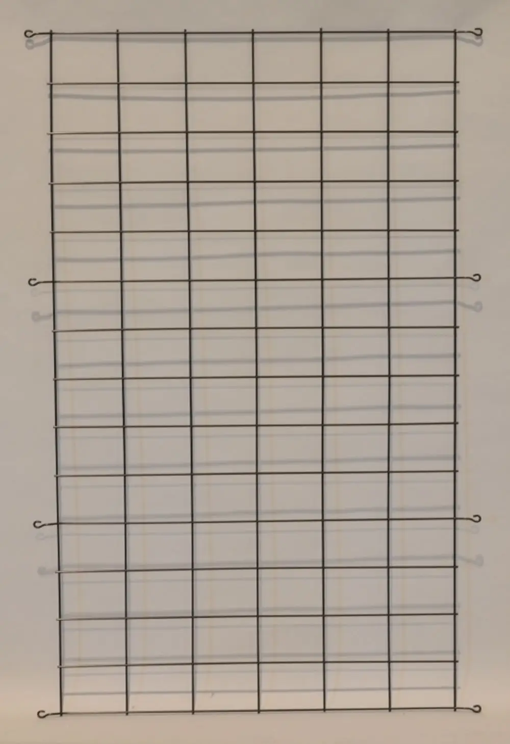 Schwarzes Gitter mit gleichmäßigem Rautenmuster, aufgehängt. Eignet sich als Schutzgitter für Verflüssiger und ist von der Marke Remko.