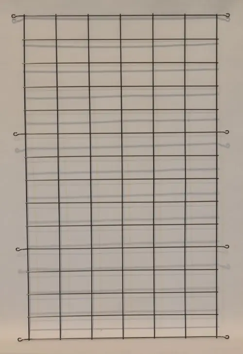 Schwarzes Gitter mit gleichmäßigem Rautenmuster, aufgehängt. Eignet sich als Schutzgitter für Verflüssiger und ist von der Marke Remko.