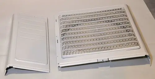 Vorderwand eines Geräts von Remko, bestehend aus zwei Teilen: einem Gitterelement und einer flachen Abdeckung in Weiß.