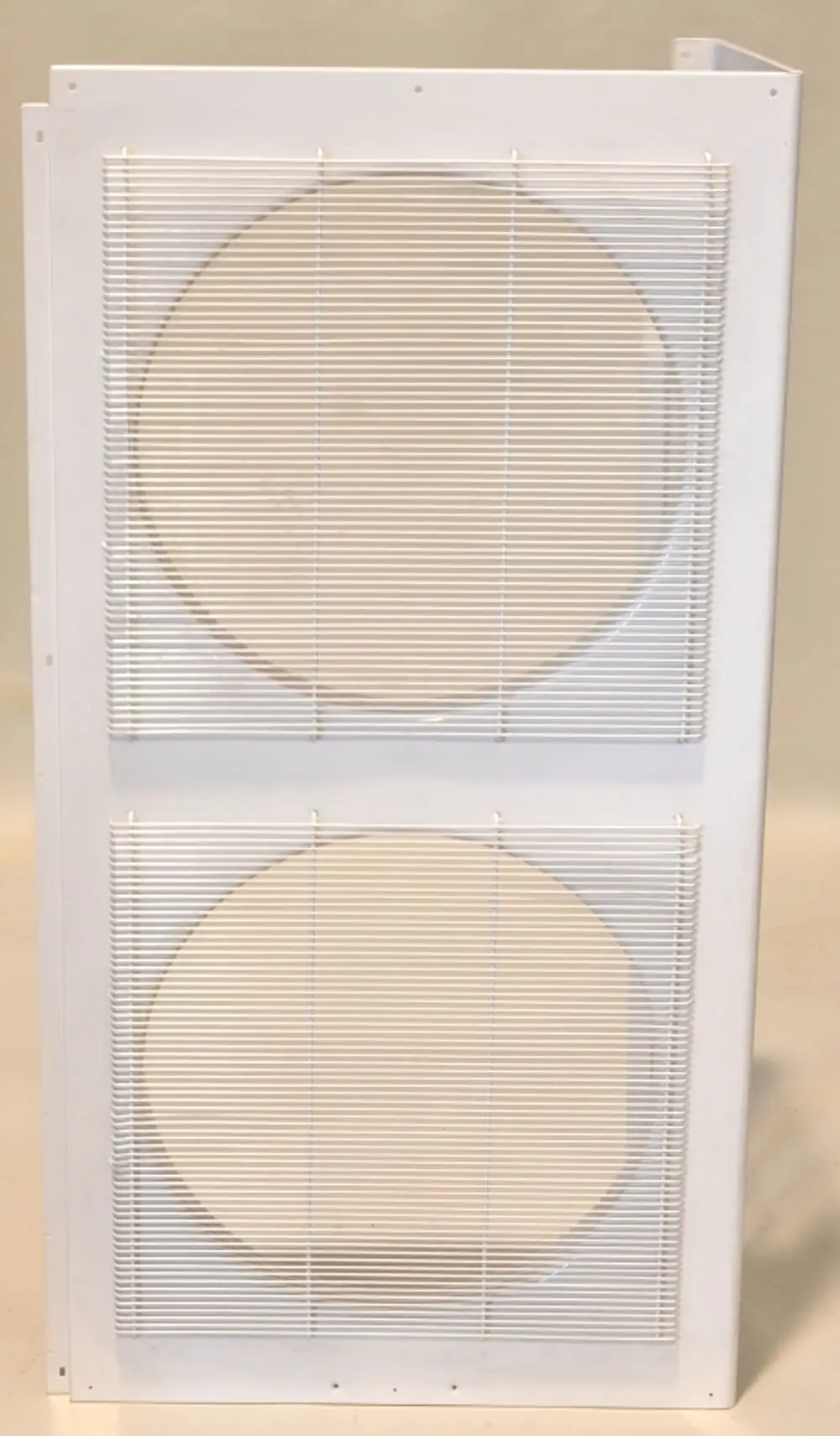 Weißes Ventilatorpaneel mit zwei runden Öffnungen, ausgestattet mit einem Gitter aus vertikalen Drähten. Hersteller: Remko.
