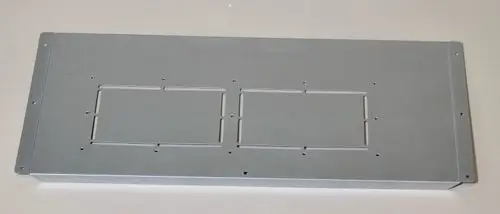 Graue Metallverkleidung mit zwei rechteckigen Ausschnitten und mehreren Befestigungslöchern, wahrscheinlich für eine Remko-Geräteeinheit.