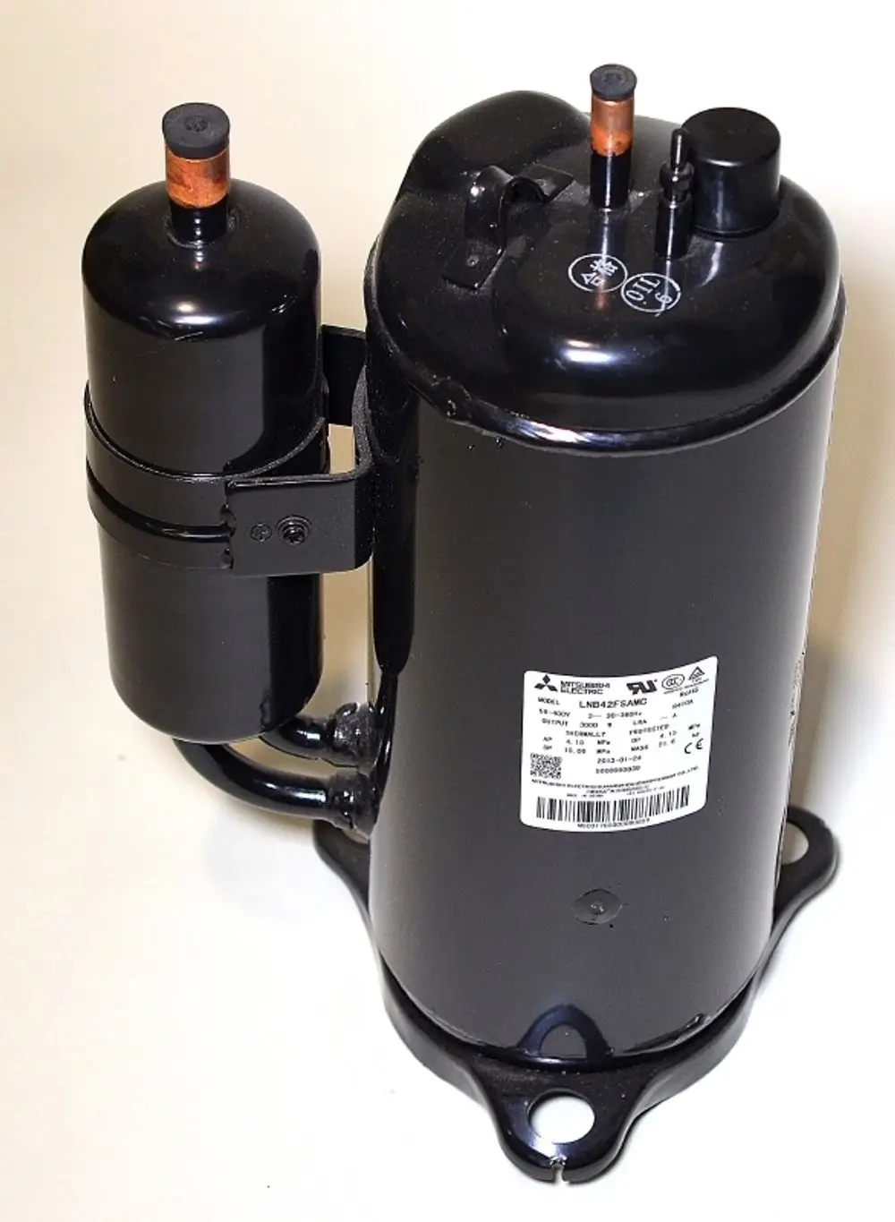Schwarzer Kompressor von Remko mit zwei Anschlüssen und einem Typenschild. Der Kompressor ist für Anwendungen in Kühlsystemen ausgelegt.