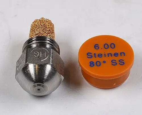 Öldüse mit metallischer Spitze und goldfarbener Filteraufsatz, neben einer markanten Orange-Plastikkappe mit Beschriftung. Produkt ist von Remko.