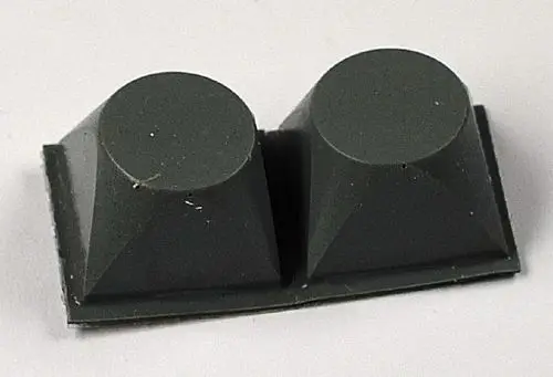 Zwei graue, pyramidenförmige Wandabstandshalter auf einer flachen Basis, sichtbar mit Staub, geeignet für Anwendungen von Remko.
