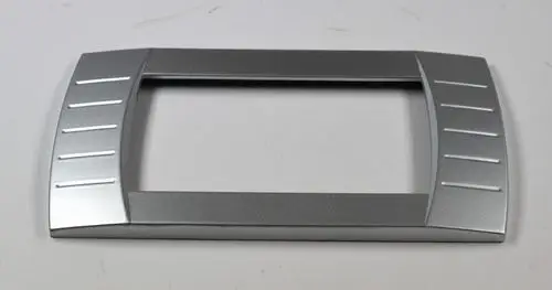 Silberne Blende für ein Bedienpanel mit seitlichen Rillen, hergestellt von Remko. Die rechteckige Form ist auf einer neutralen Fläche platziert.