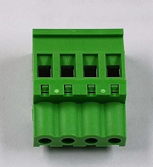 Grüner Anschlussblock mit mehreren Klemmen zur elektrischen Verbindung, hergestellt von Remko. Drei obere Klemmen und mehrere untere Anschlussöffnungen sind sichtbar.