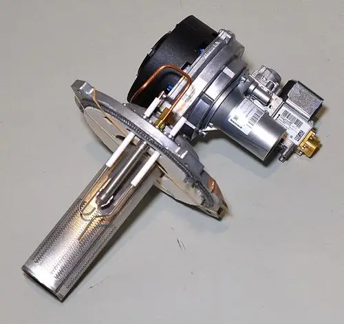 Gasbrenner von Remko mit einem rechteckigen metallischen Gehäuse, einer Zündelektrode und Rohrleitungen. Sichtbare Komponenten für Gaszufuhr und elektrische Anschlüsse.