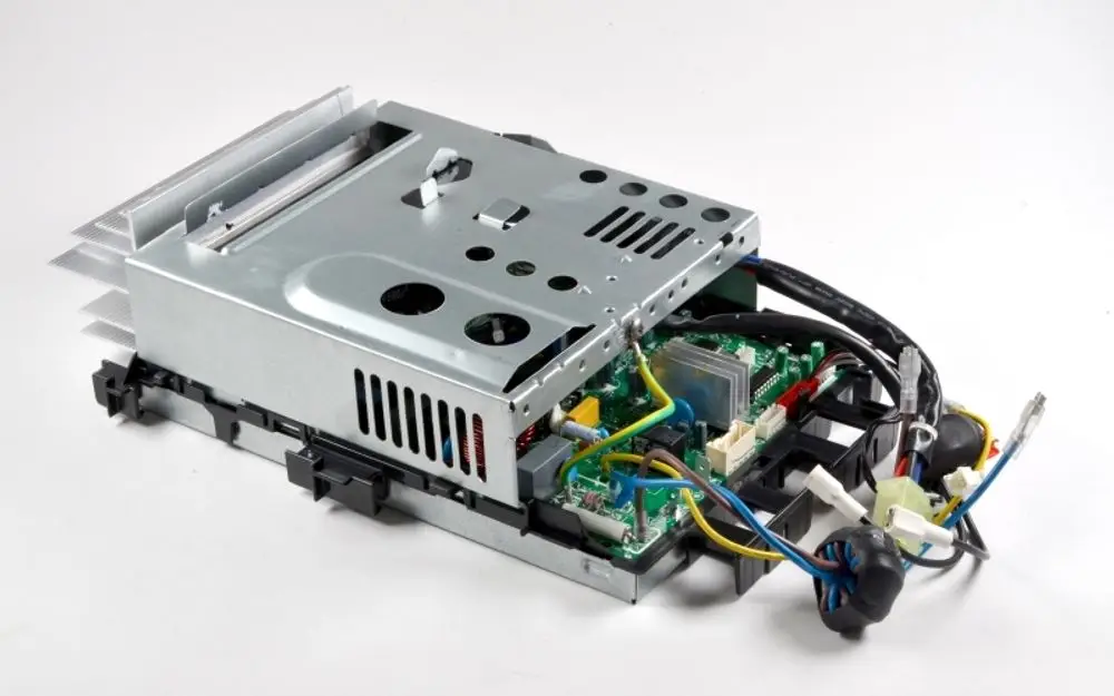 E-Box von Remko, teilweise geöffnet, zeigt interne Elemente wie Steuerplatine, Kühlkörper und elektrische Verbindungen in einer metallischen Gehäusekonstruktion.