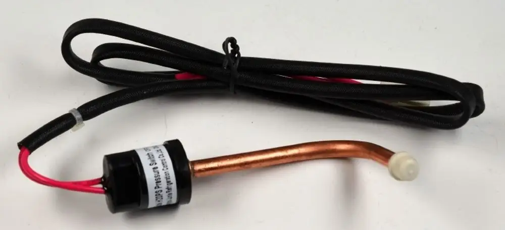 Niederdrucksensor von Remko mit einem schwarzen Kabel und einem kupferfarbenen Rohr. Das Kabel hat zwei Drähte, die aus einer Schutzhülle herausragen.