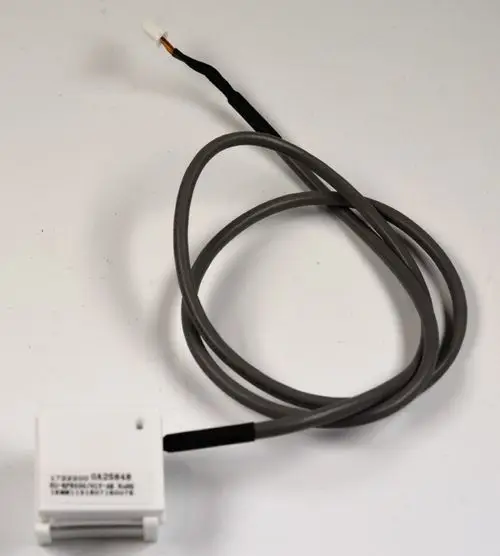 Zusatzplatine von Remko mit einem Kabel und einem Anschlussstecker. Die Platine hat eine weiße Gehäusefarbe und ist für elektrische Anwendungen vorgesehen.
