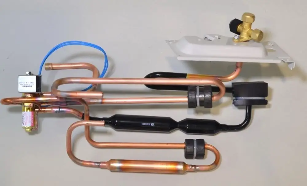 Rohrbaugruppe mit vier Kupferrohren, Ventil und elektrischen Anschlüssen, verwendet in der Klimaanlagentechnologie, möglicherweise von Remko.