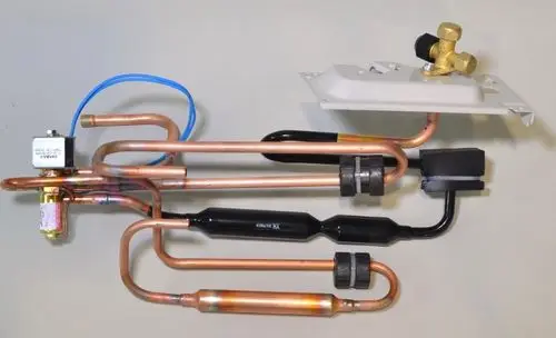 Rohrbaugruppe mit vier Kupferrohren, Ventil und elektrischen Anschlüssen, verwendet in der Klimaanlagentechnologie, möglicherweise von Remko.