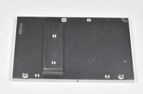 Aluminiumplatte mit mehreren Bohrungen und einer centralen Erhebung. Produkt von Remko, geeignet für Montageanwendungen. Oberfläche zeigt leichte Gebrauchsspuren.