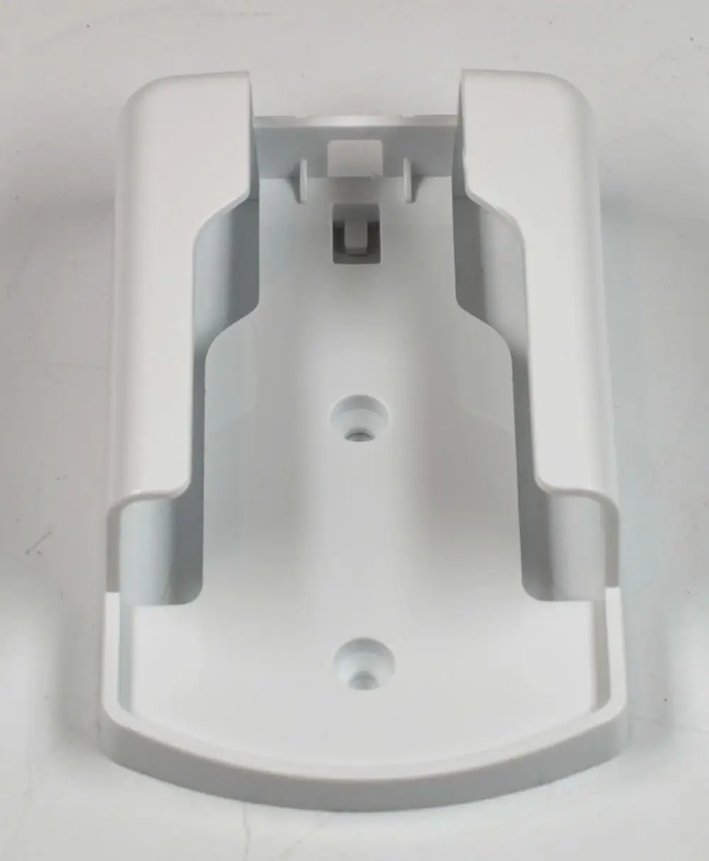 Weißer Halter für eine Fernbedienung, gefertigt von Remko, mit zwei Löchern zur Befestigung an einer Wand und offenen Seiten für das Einsetzen der Fernbedienung.