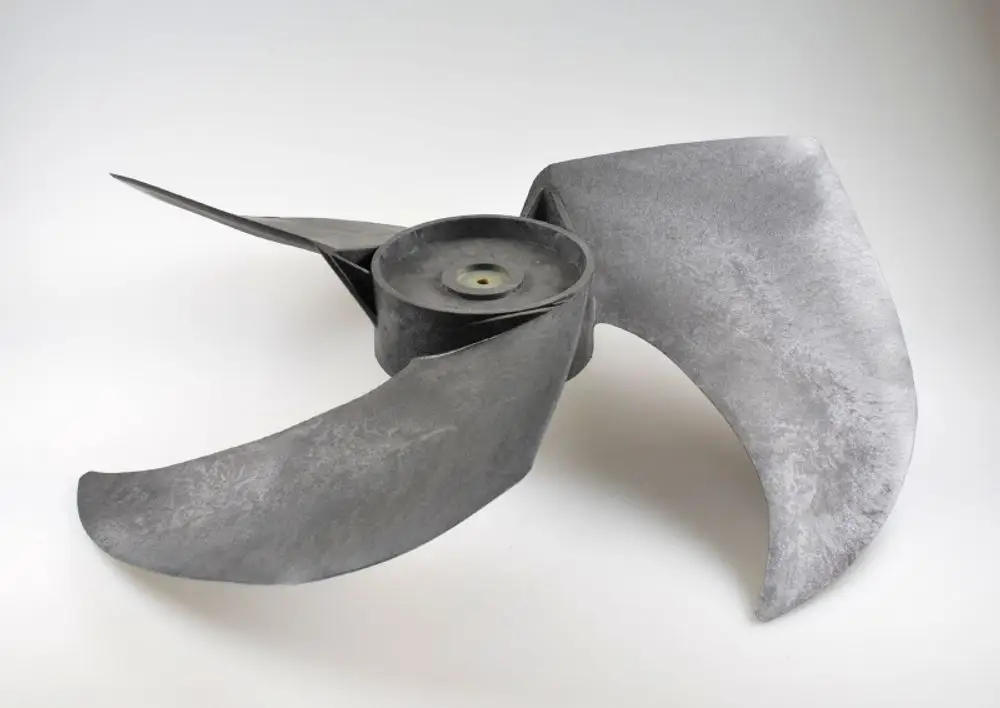 Ventilatorflügel von Remko mit drei gebogenen Blättern, die um eine zentrale Achse angeordnet sind. Die Oberfläche ist grau und matt.