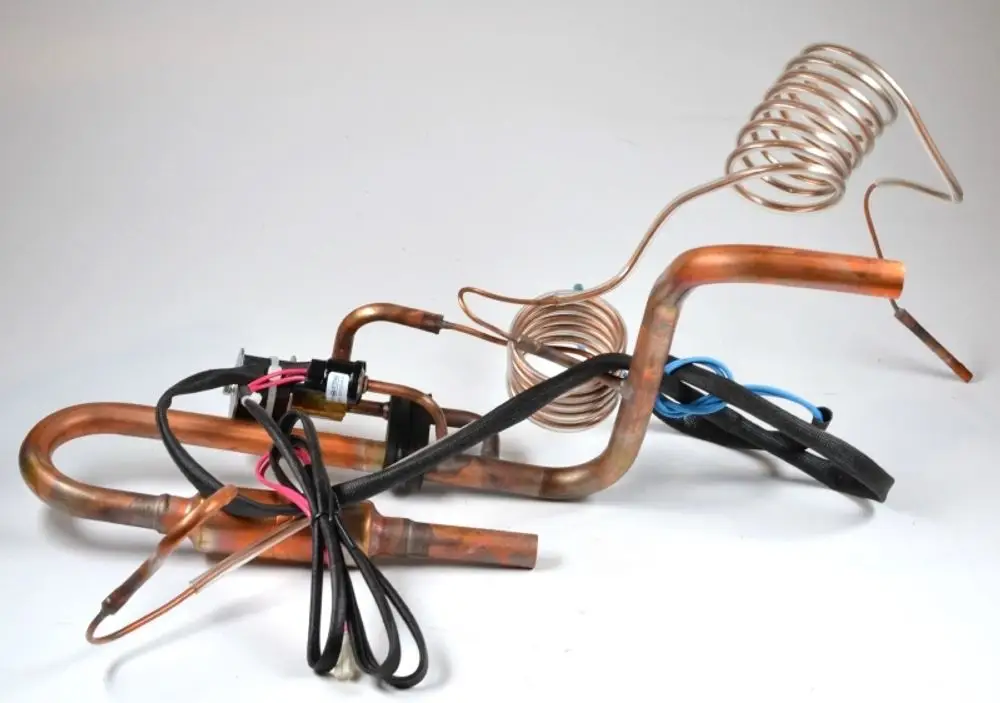 Kupferrohre mit elektrischen Anschlüssen, die zu einem Saugleitung-Set von Remko gehören. Das Set enthält gebogene und gerade Abschnitte für verschiedene Anwendungen.