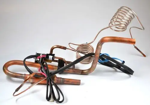 Kupferrohre mit elektrischen Anschlüssen, die zu einem Saugleitung-Set von Remko gehören. Das Set enthält gebogene und gerade Abschnitte für verschiedene Anwendungen.