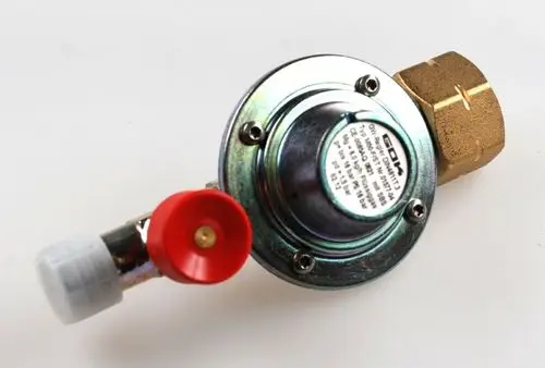 Druckregler von Remko mit metallischem Gehäuse und zwei Anschlüssen, einer mit rotem Ventil und einem Schutzabschluss. Er dient der Druckregulierung in einem System.