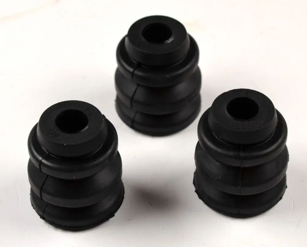 Drei schwarze Gummi-Schwingungsdämpfer von Remko, mit einer gestuften Form und hohlen Zentren, auf weißem Hintergrund.