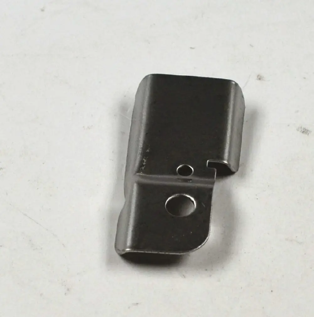 Metallisches Bauteil mit zwei Öffnungen, gefertigt von Remko. Das Teil hat eine rechteckige Form mit abgerundeten Kanten und einer seitlichen Einbuchtung.