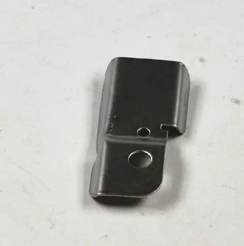 Metallisches Bauteil mit zwei Öffnungen, gefertigt von Remko. Das Teil hat eine rechteckige Form mit abgerundeten Kanten und einer seitlichen Einbuchtung.