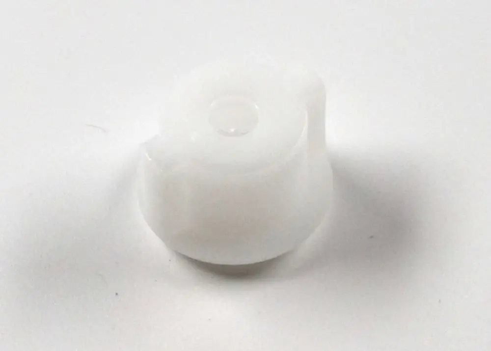 Weiße Pumpenkupplung von Remko, zylindrische Form mit mittigem Muldenbereich und einem seitlichen Abschnitt. Klarheit im Design ohne zusätzliche Markierungen.
