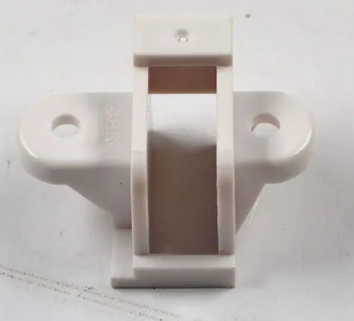 Halterung für Mikroschalter, aus Kunststoff in Weiß, mit zwei Montageöffnungen, hergestellt von Remko. Flache Form mit vertikaler Öffnung in der Mitte.
